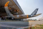 Airbus A350F carguero saliendo del hangar de pintura con su nueva librea color cartón, con las inscripciones A350F y "Open here for business" en el fuselaje